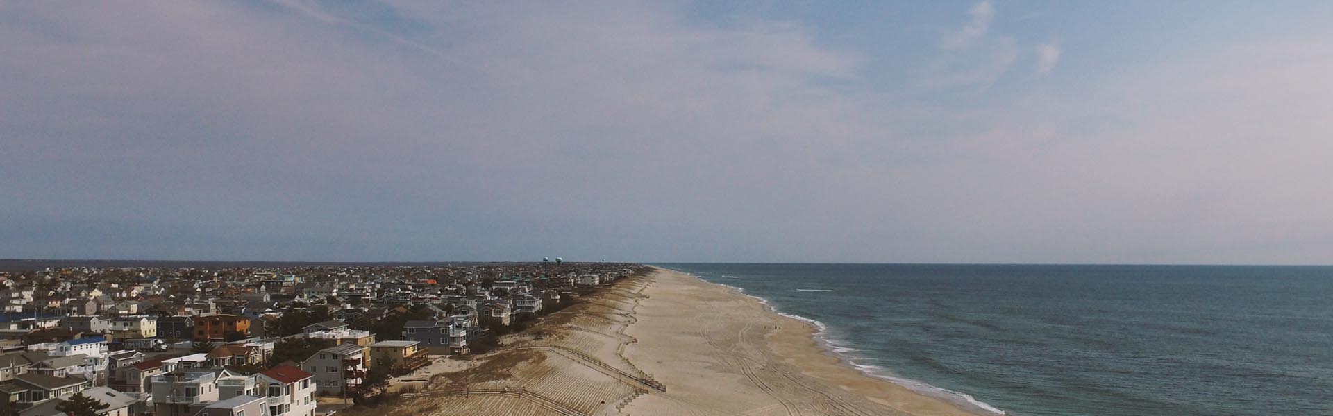 aeriel view of coastline with house, then beach, then ocean. photo by Jack Hamilton
