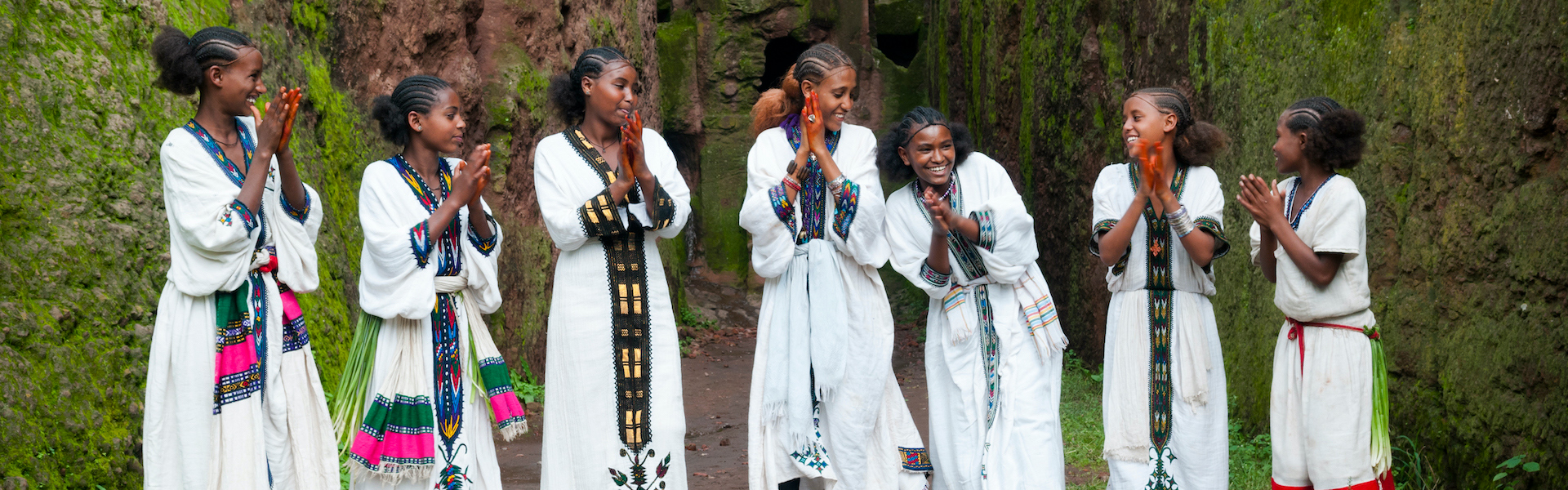 Seven Ethiopian woman standing and clapping in traditional dress